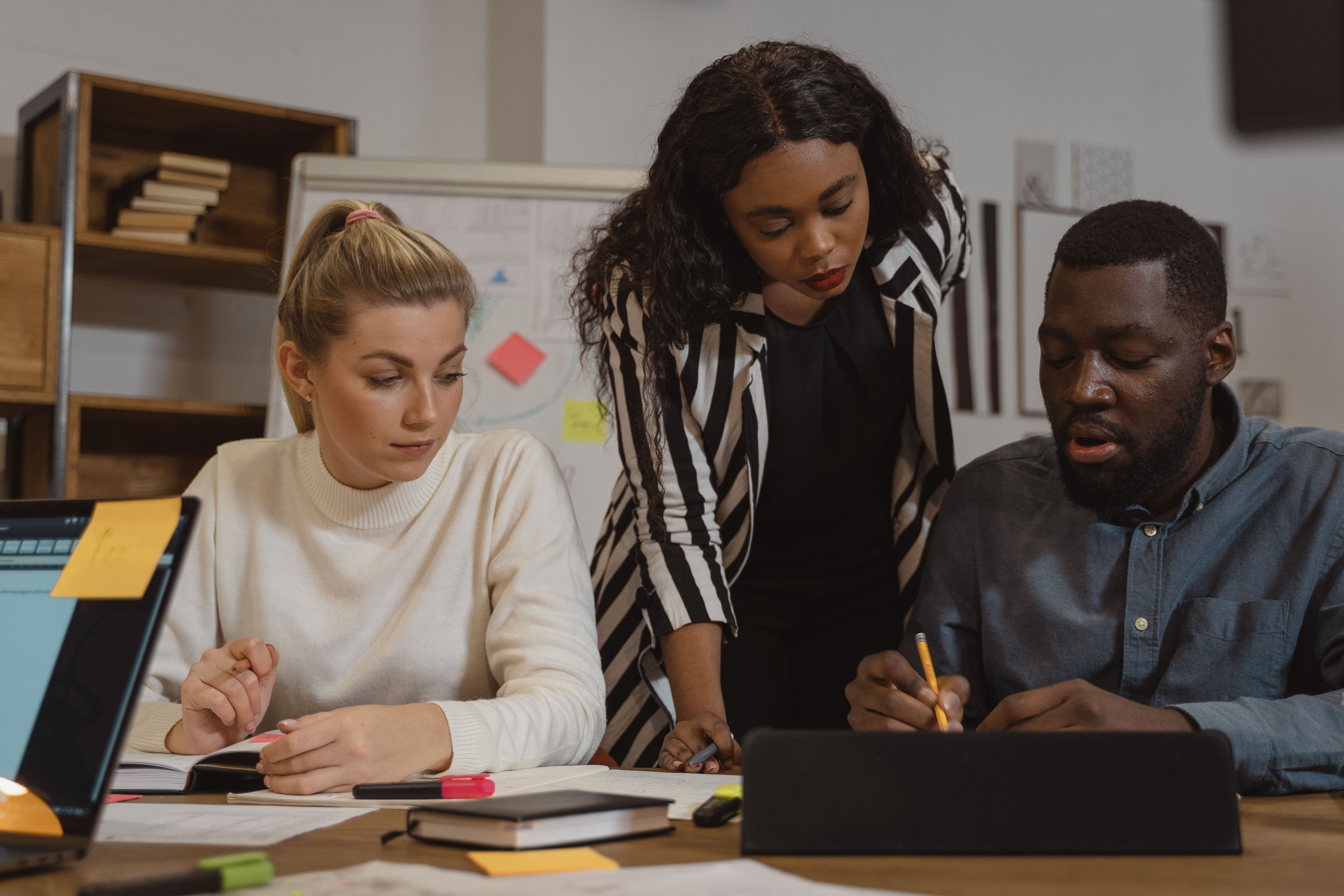 Facilitator coaching two colleagues during a workplace training session